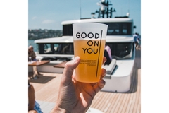 Image A hand holding a reusable cup on a boat.
